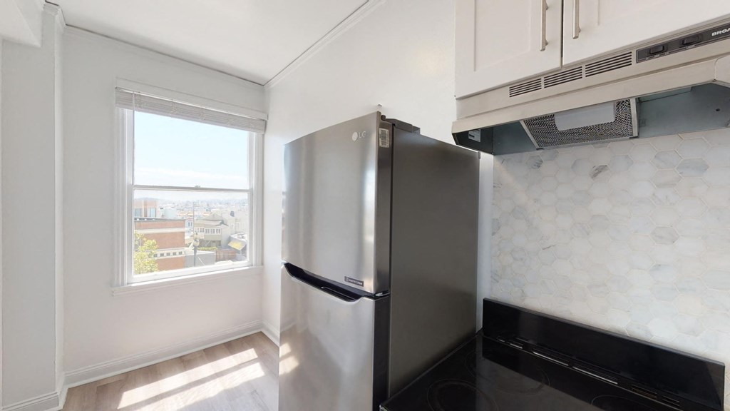 a kitchen with a stainless steel refrigerator and a window