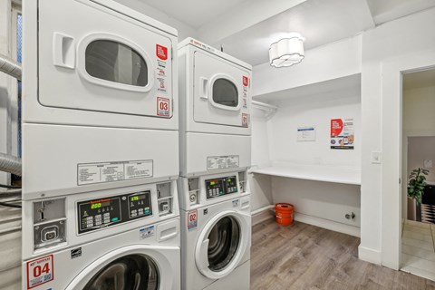 A laundry room with two washing machines and a bench.
