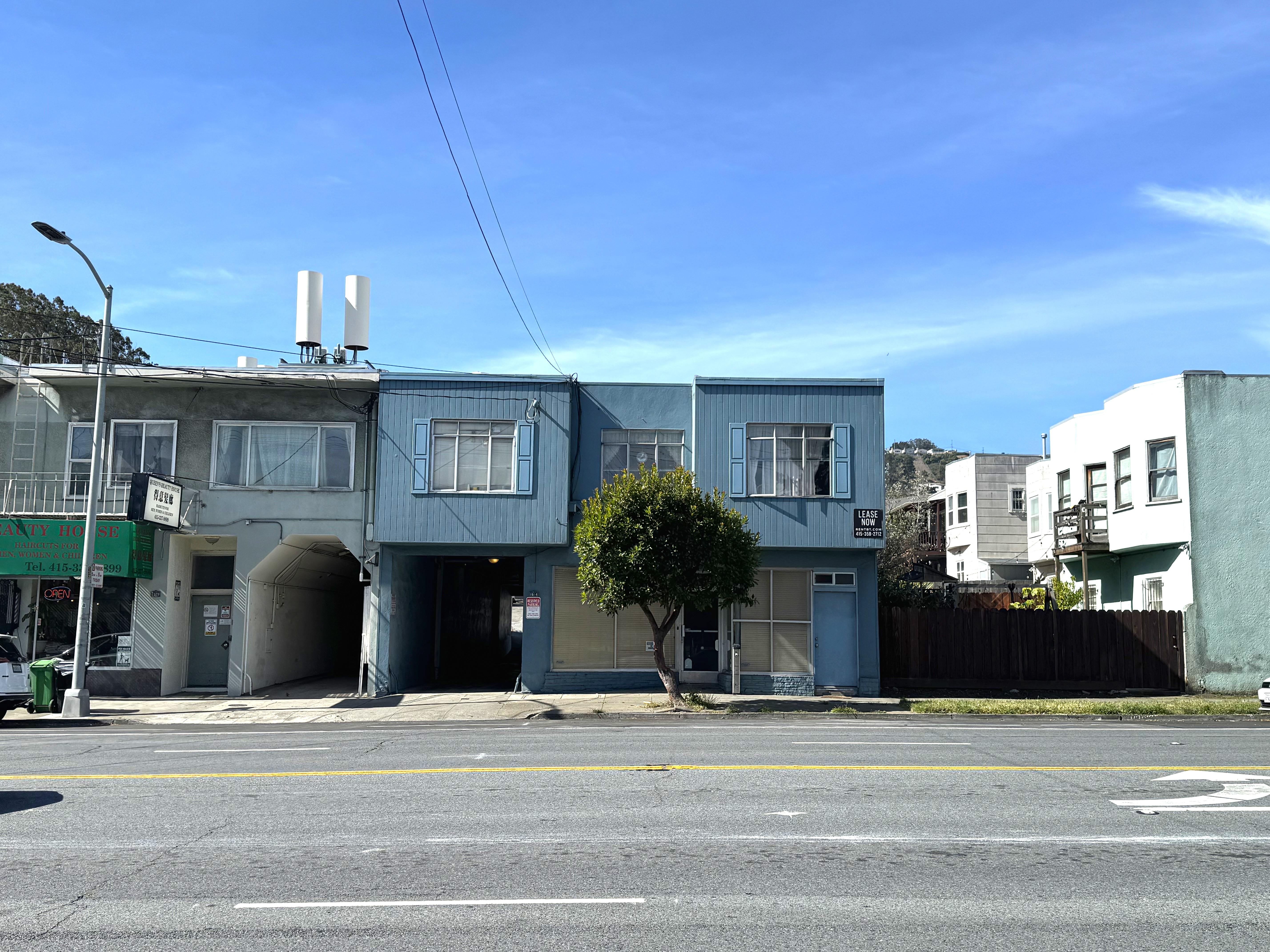A blue building with a tree in front of it.