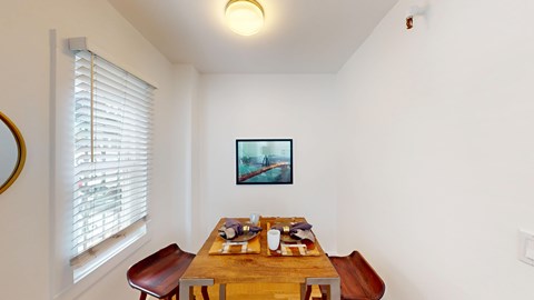 A dining room with a wooden table and chairs.
