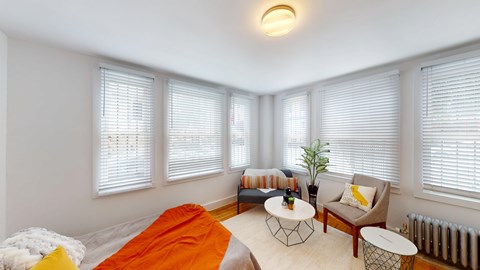 A bright room with a bed, a chair, and a table.