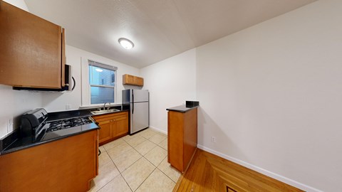 A kitchen with a stove top oven and a refrigerator.