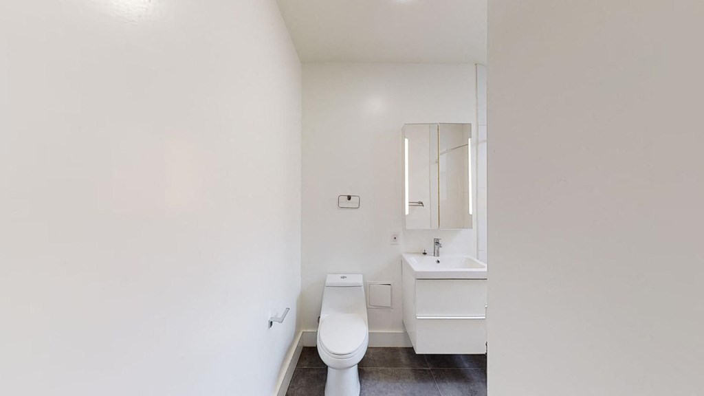 a white bathroom with a toilet and a sink
