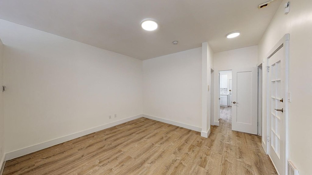 a living room with white walls and wood floors