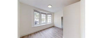 a living room with white walls and a large window