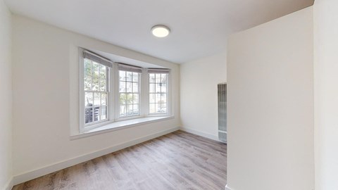 a living room with white walls and a large window