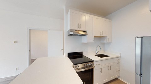 a kitchen with white cabinets and a stove and a refrigerator