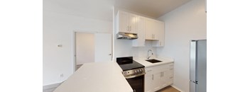 a kitchen with white cabinets and a stove and a refrigerator