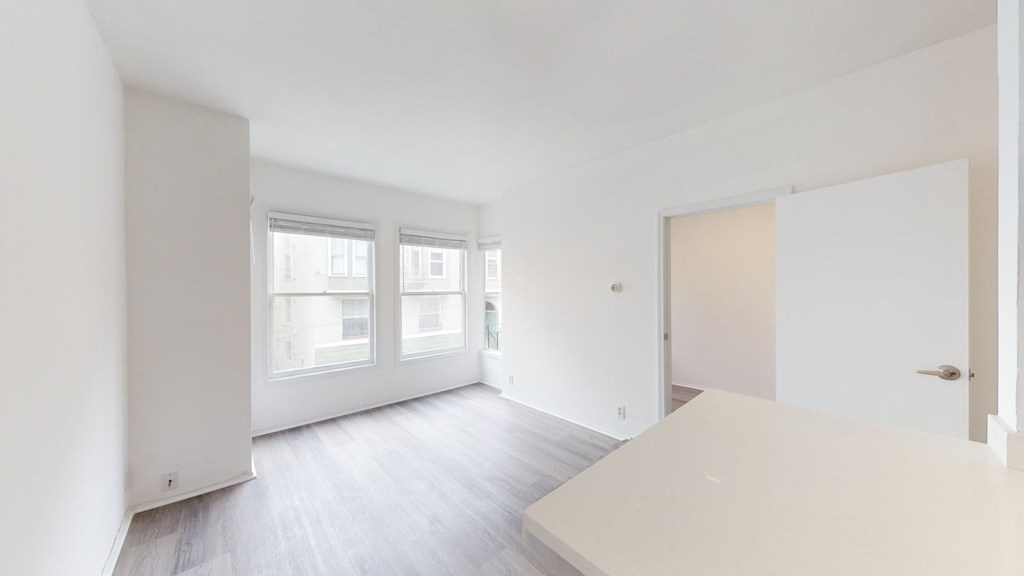 an empty living room with white walls and wood floors