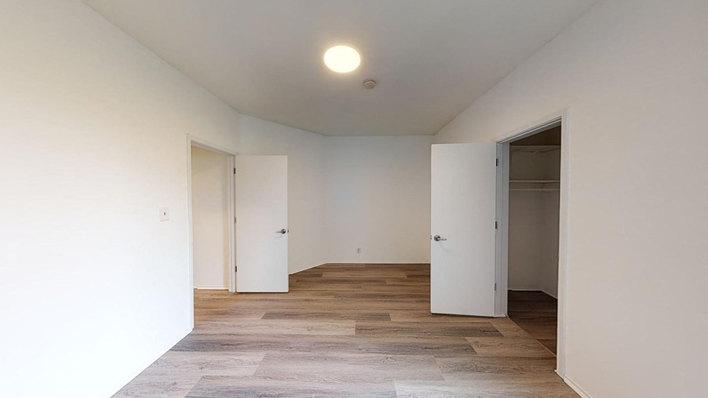 a renovated living room with white walls and wood floors