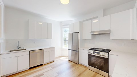 A kitchen with white cabinets and stainless steel appliances.
