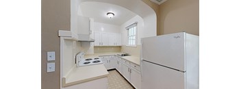 a white kitchen with a refrigerator and a sink