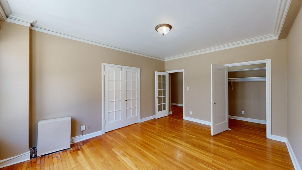 an empty living room with wood floors and a door to a closet
