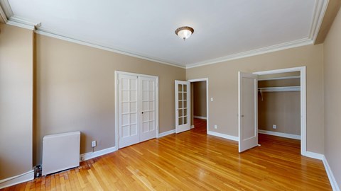 A room with a wooden floor and a white ceiling light.