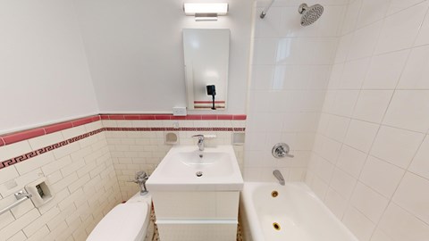A white bathroom with a toilet, sink, and bathtub.