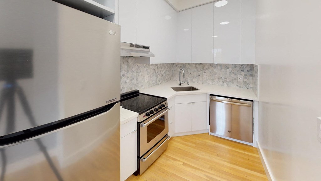 a kitchen with white cabinets and stainless steel appliances