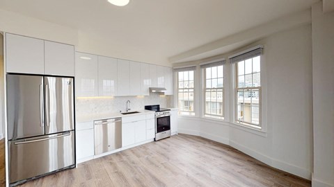 a kitchen with white cabinets and a stainless steel refrigerator