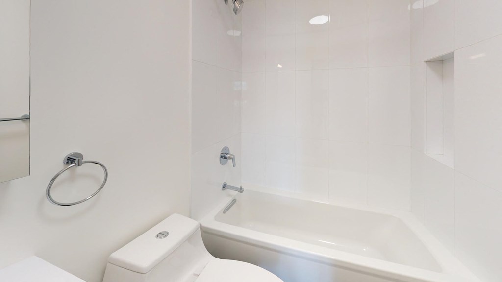 a white bathroom with a tub and a toilet