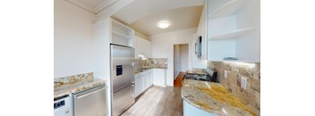 a kitchen with stainless steel appliances and marble counter tops