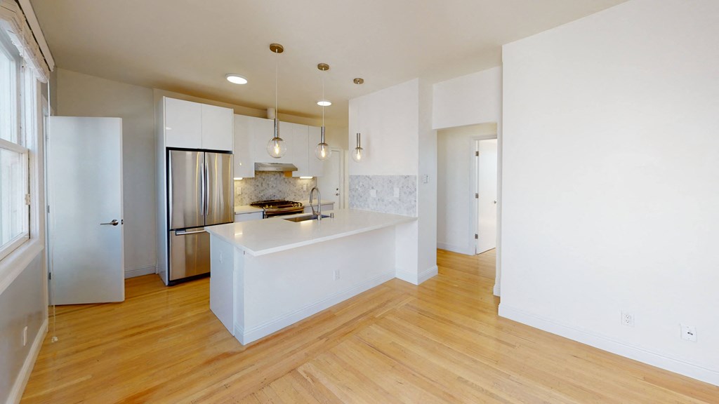 a renovated kitchen with white cabinets and a white counter top