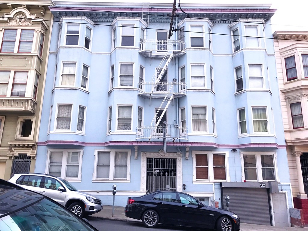 a blue and white building with cars parked in front of it