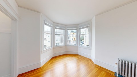 A room with a wooden floor and white walls.
