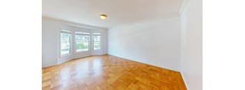 an empty living room with wood floors and a window