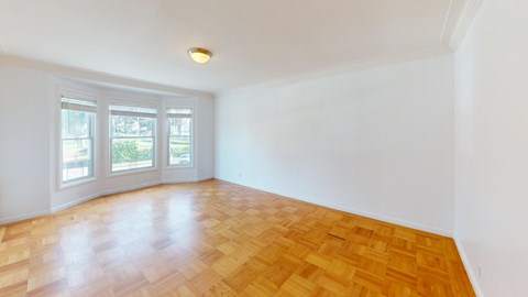 an empty living room with wood floors and a window