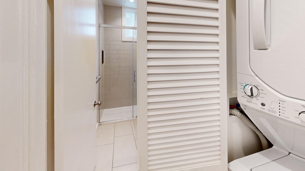 a small bathroom with a washer and dryer and a closet