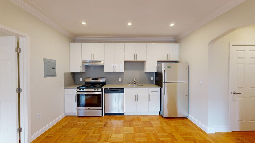 a kitchen with white cabinets and stainless steel appliances