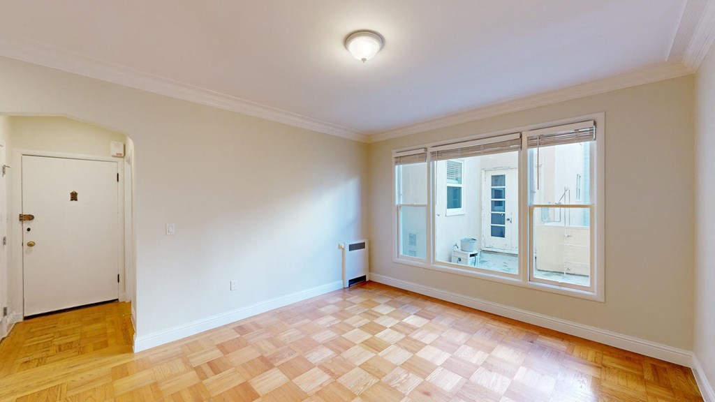a living room with a large window and wooden floors