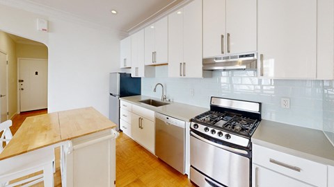a kitchen with white cabinets and stainless steel appliances