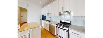 a kitchen with white cabinets and stainless steel appliances