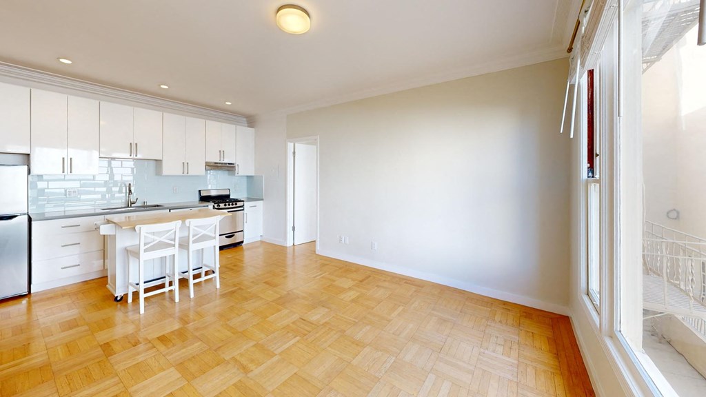 a kitchen and dining room with white cabinets and a wood floor