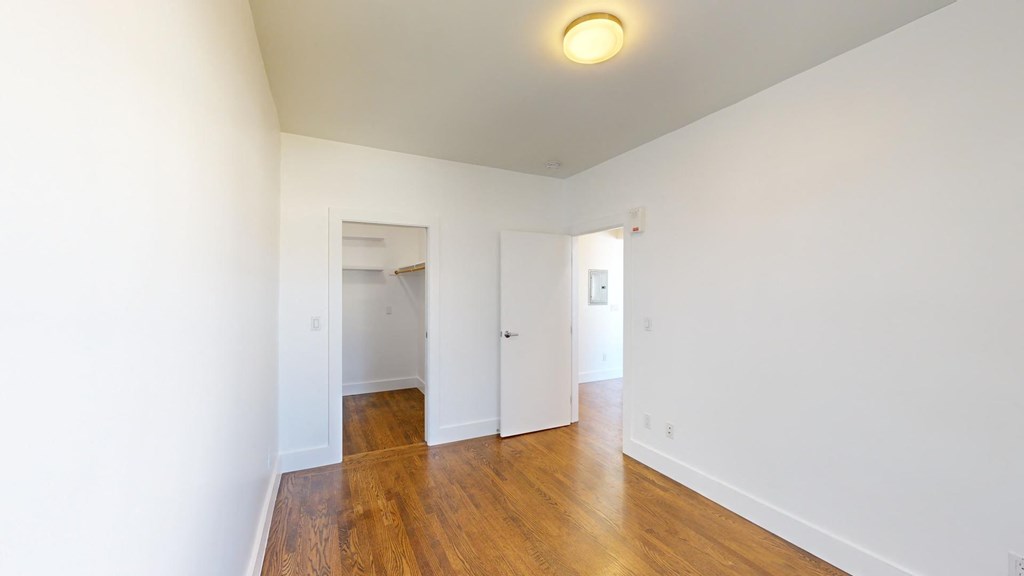 a renovated living room with white walls and wood floors