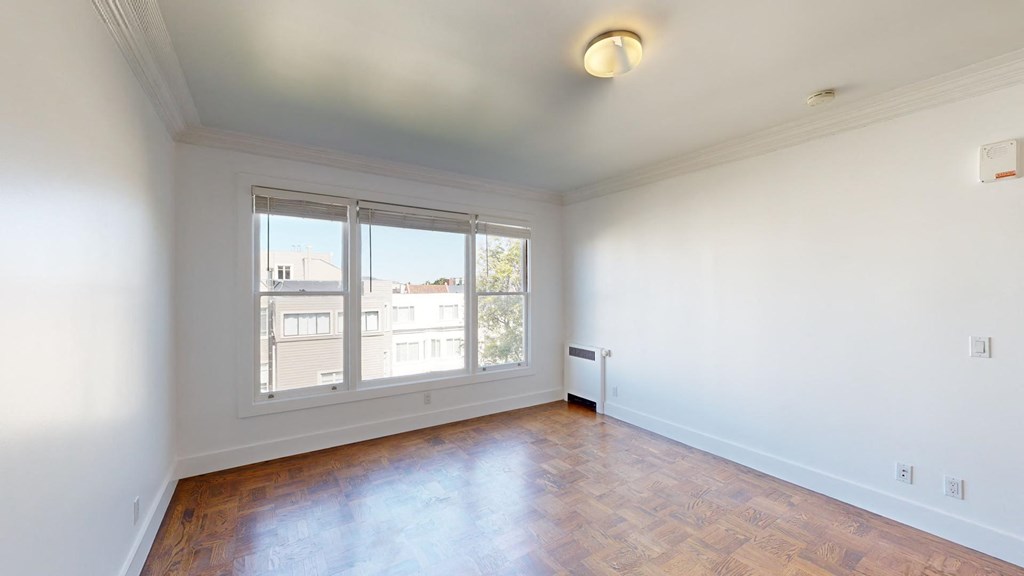 a living room with a large window and wooden floors