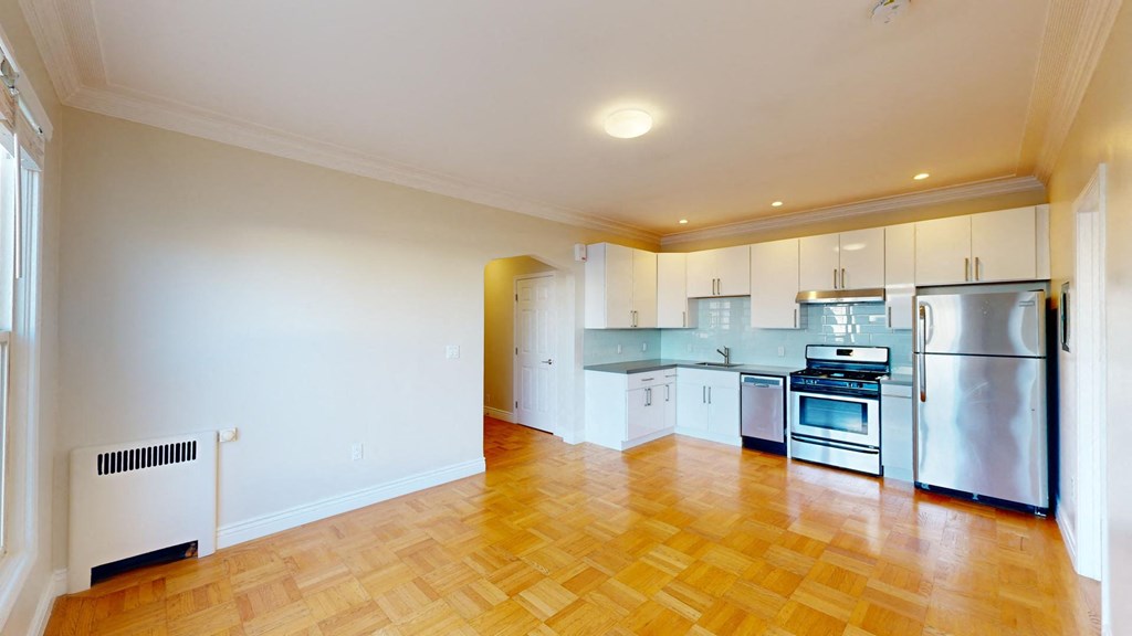 a kitchen with stainless steel appliances and a wooden floor