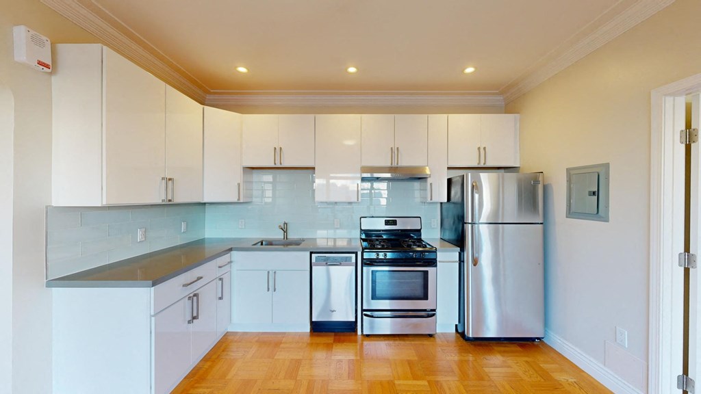 a kitchen with white cabinets and stainless steel appliances