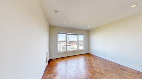 Empty room with wooden floors and a window.