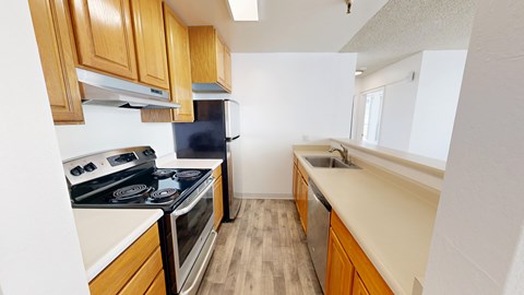A kitchen with wooden cabinets and a black fridge.