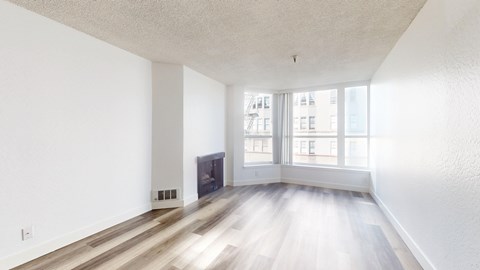A spacious living room with a fireplace and hardwood floors.