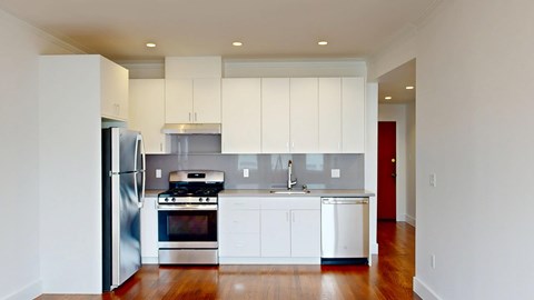 A modern kitchen with stainless steel appliances and white cabinets.