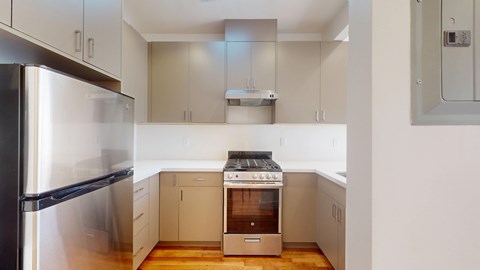 A modern kitchen with a stainless steel refrigerator and a stove top oven.