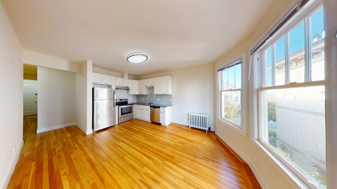 A large open room with wooden floors and white walls.