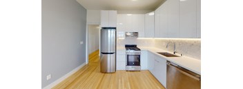 a kitchen with white cabinets and a stainless steel refrigerator