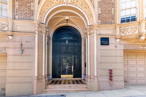 The entrance to a building with a black door and a sign that reads "BRICK".