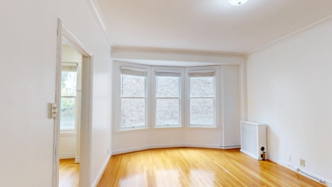 A room with a window and a radiator on the wall.