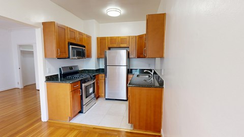 A kitchen with wooden cabinets and a black countertop.