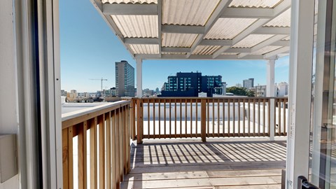 A balcony with a wooden railing and a white roof.