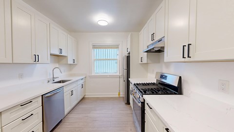A kitchen with white cabinets and a black stove top oven.